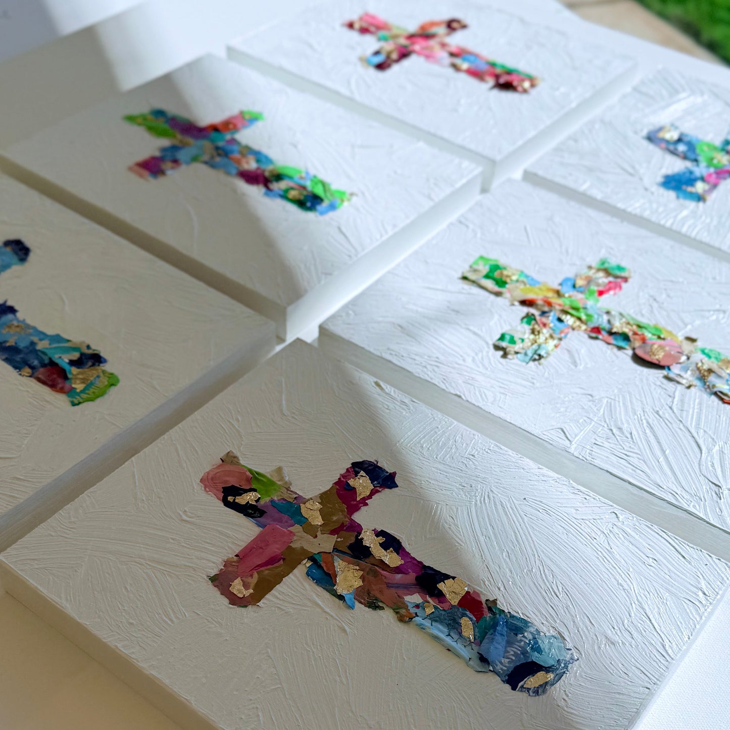 a set of 6 original cross collage paintings on a white surface