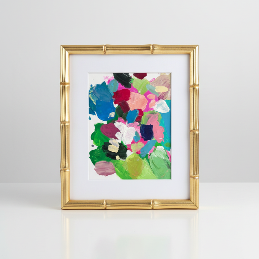 Colorful abstract art in a gold frame on a white background