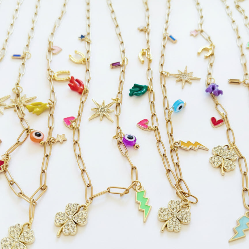 Gold necklaces with various colorful charms on a white background