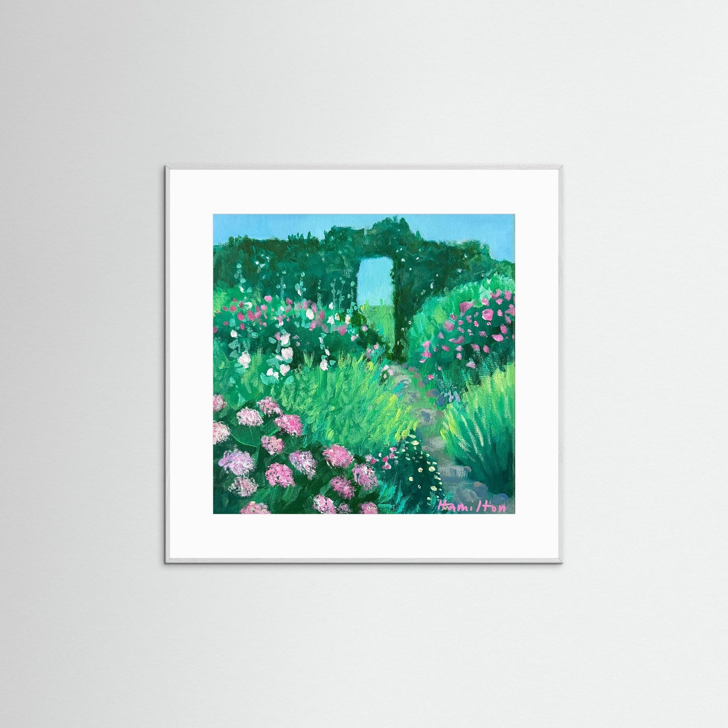 Framed artwork of a garden scene with flowers and a pathway on a white background