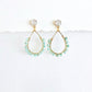 Gold teardrop earrings wrapped with Aquamarine beads on a white background by artist Julie Hamilton 