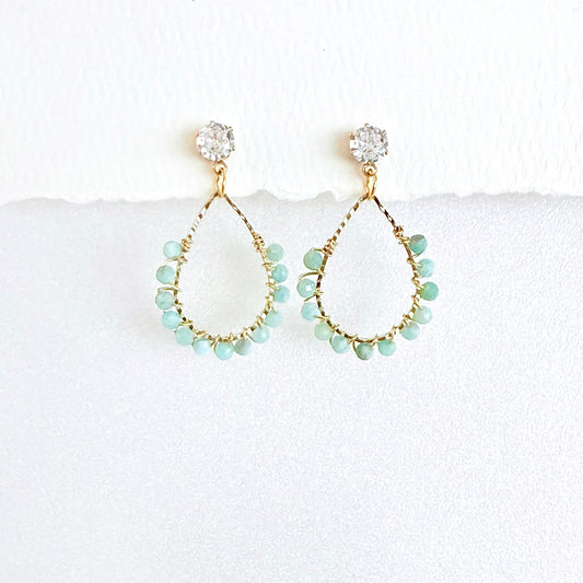 Gold teardrop earrings wrapped with Aquamarine beads on a white background by artist Julie Hamilton 