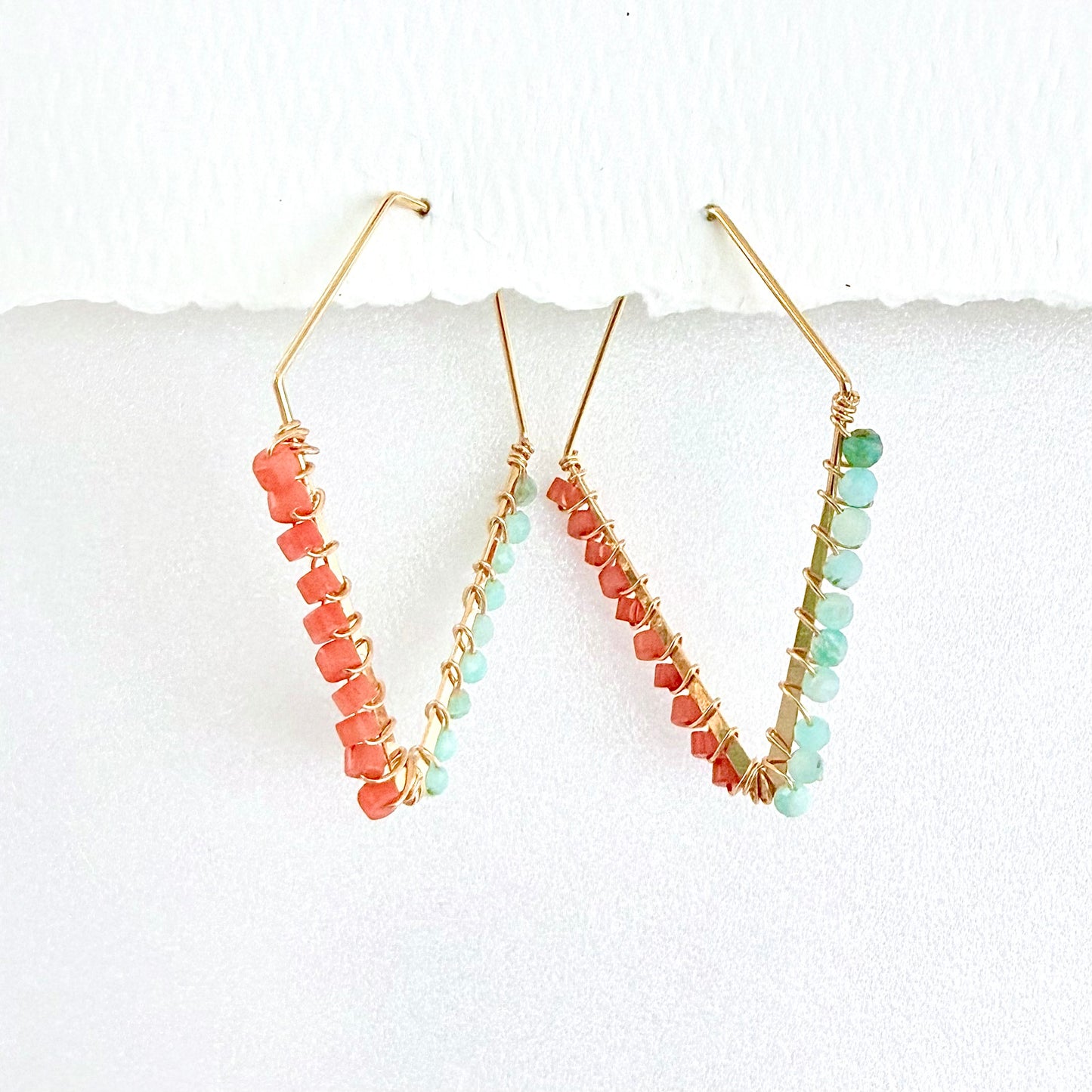 Pair of coral and ultramarine beaded hoop earrings with a white background by phoenix artist Julie Hamilton 
