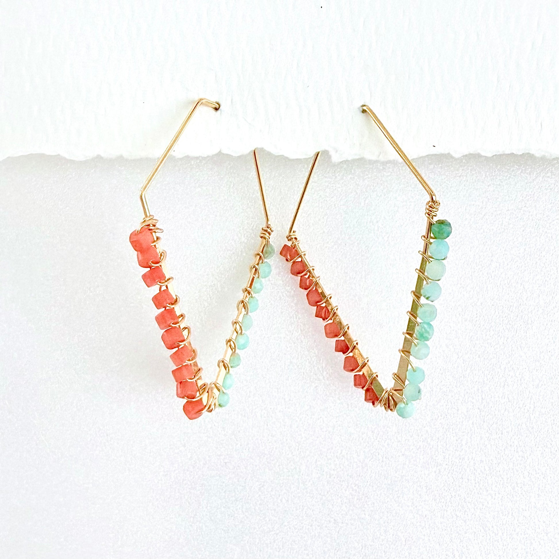 Pair of coral and ultramarine beaded hoop earrings with a white background by phoenix artist Julie Hamilton 