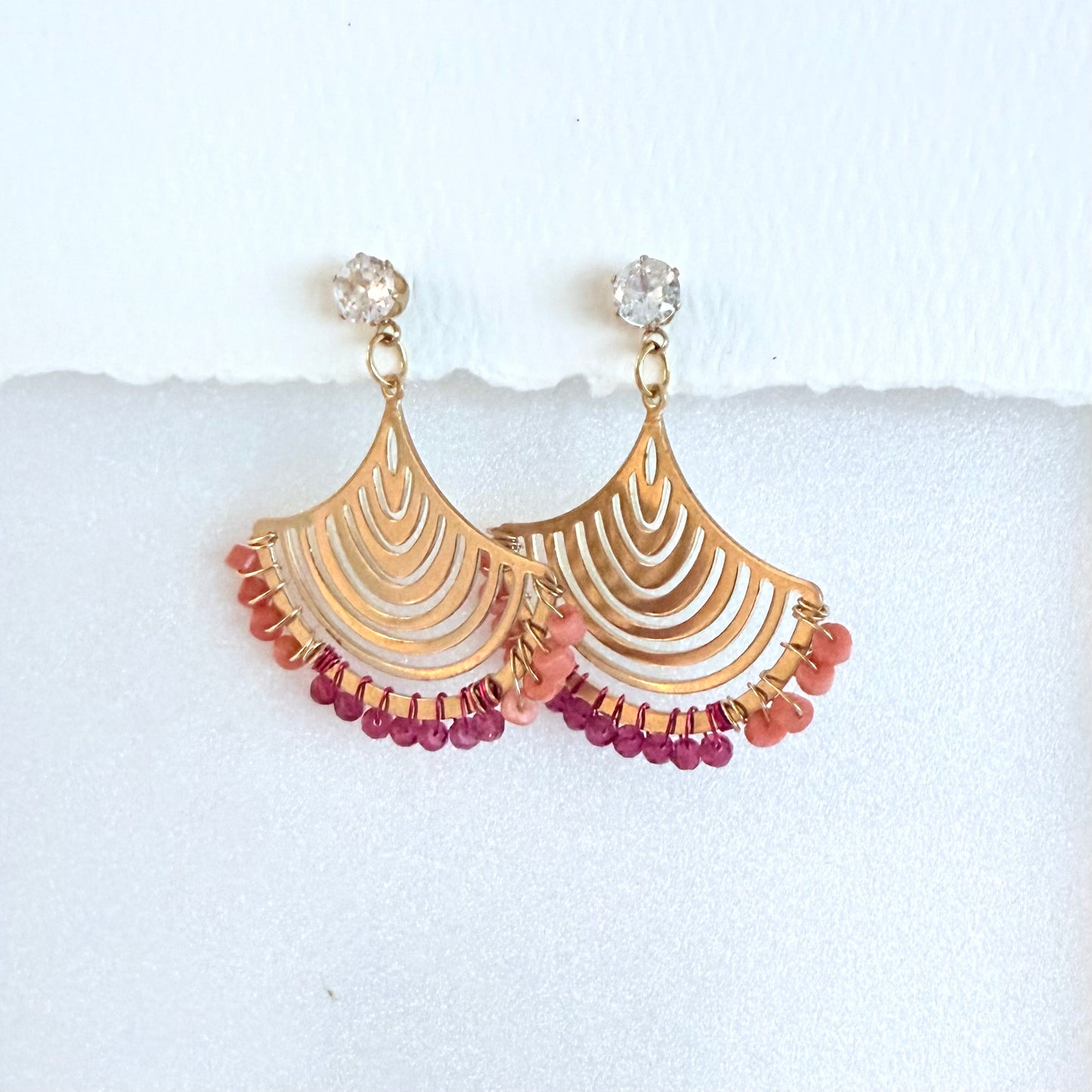 Gold fan earrings with coral and pink beads on a white background by artist Julie Hamilton 