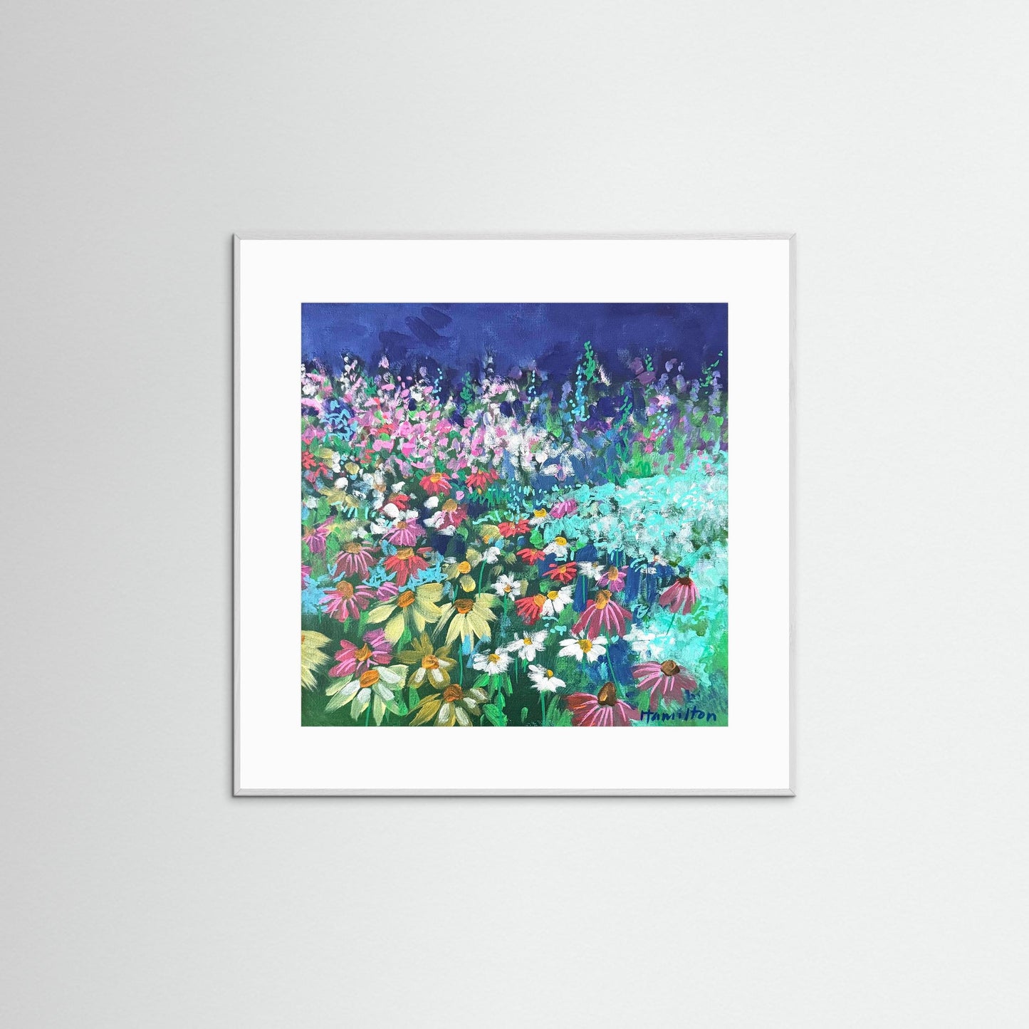 white Framed artwork of a colorful floral scene on a white wall
