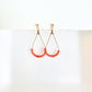 Pair of gold teardrop earrings with coral beads on a white background by artist Julie Hamilton