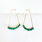 Gold hoop earrings with green beads on a white background by phoenix artist Julie Hamilton