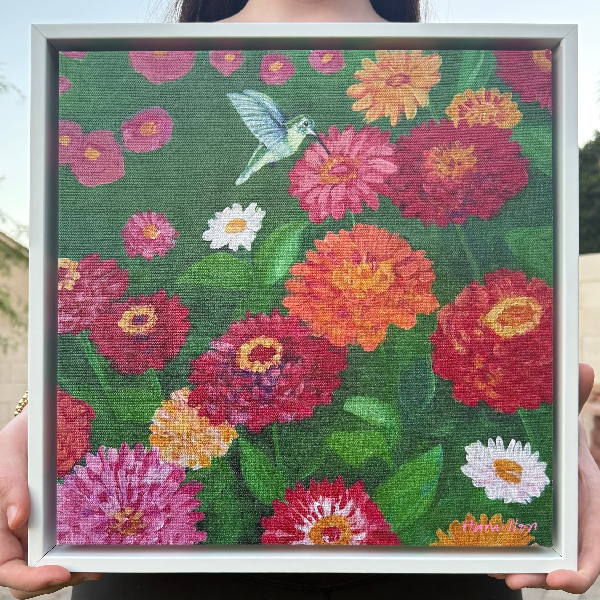 Framed artwork of colorful zinnia flowers with a hummingbird by phoenix artist Julie Hamilton