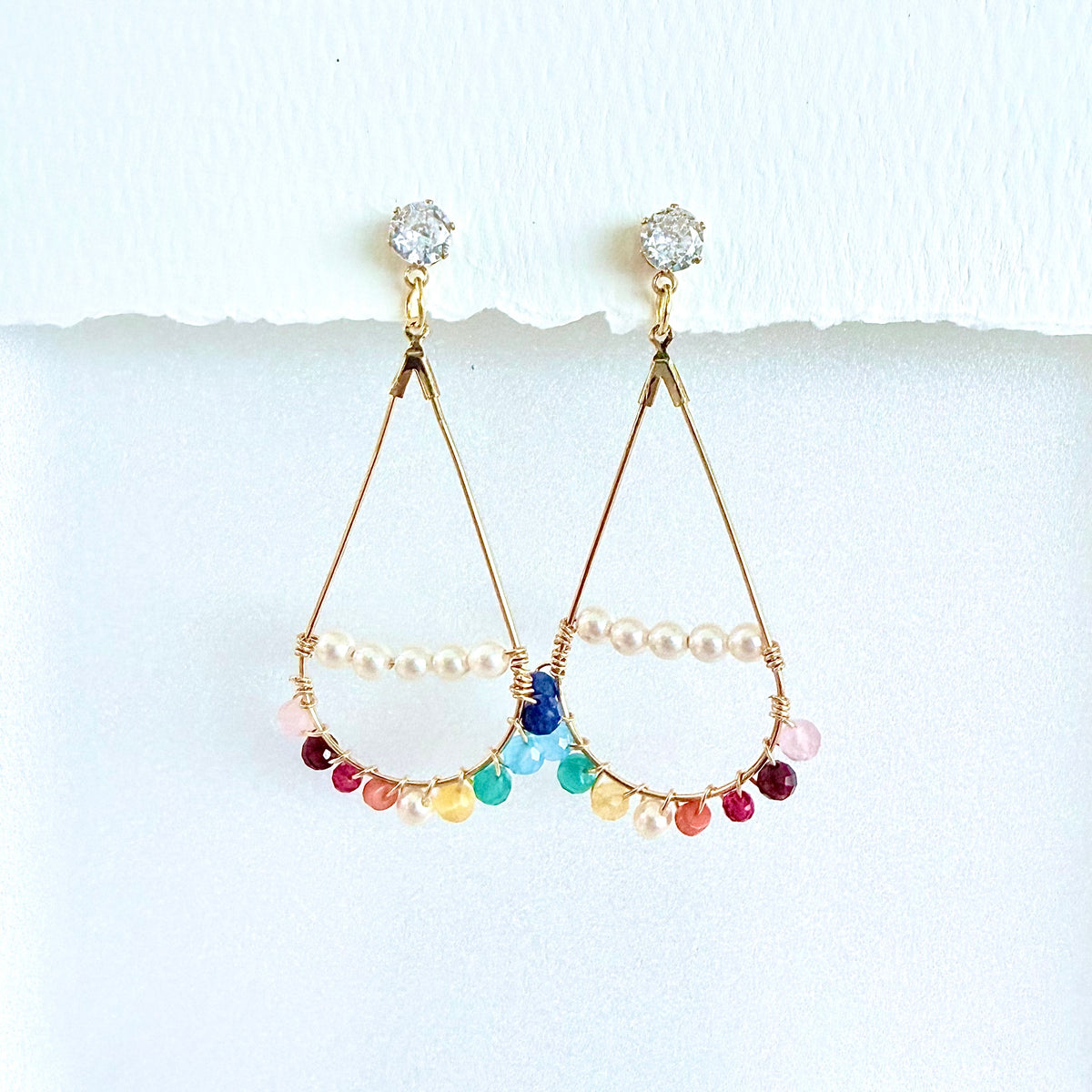 Colorful gemstone beaded teardrop earrings in gold on a white background by Phoenix artist Julie Hamilton