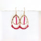 Gold hoop earrings with pink beads on a white background by Phoenix artist Julie Hamilton