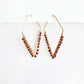 Pair of gold hoop earrings with sparkling brown sunstone beads on a white background by artist Julie Hamilton