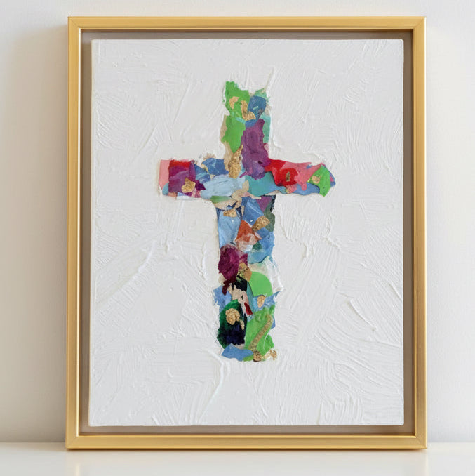 Framed artwork of a colorful collage cross on a white canvas with gold leaf on a white background