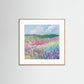 Framed artwork of a colorful landscape with flowers and mountains on a white wall.