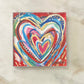 Colorful heart design on a red background with a white marble surface