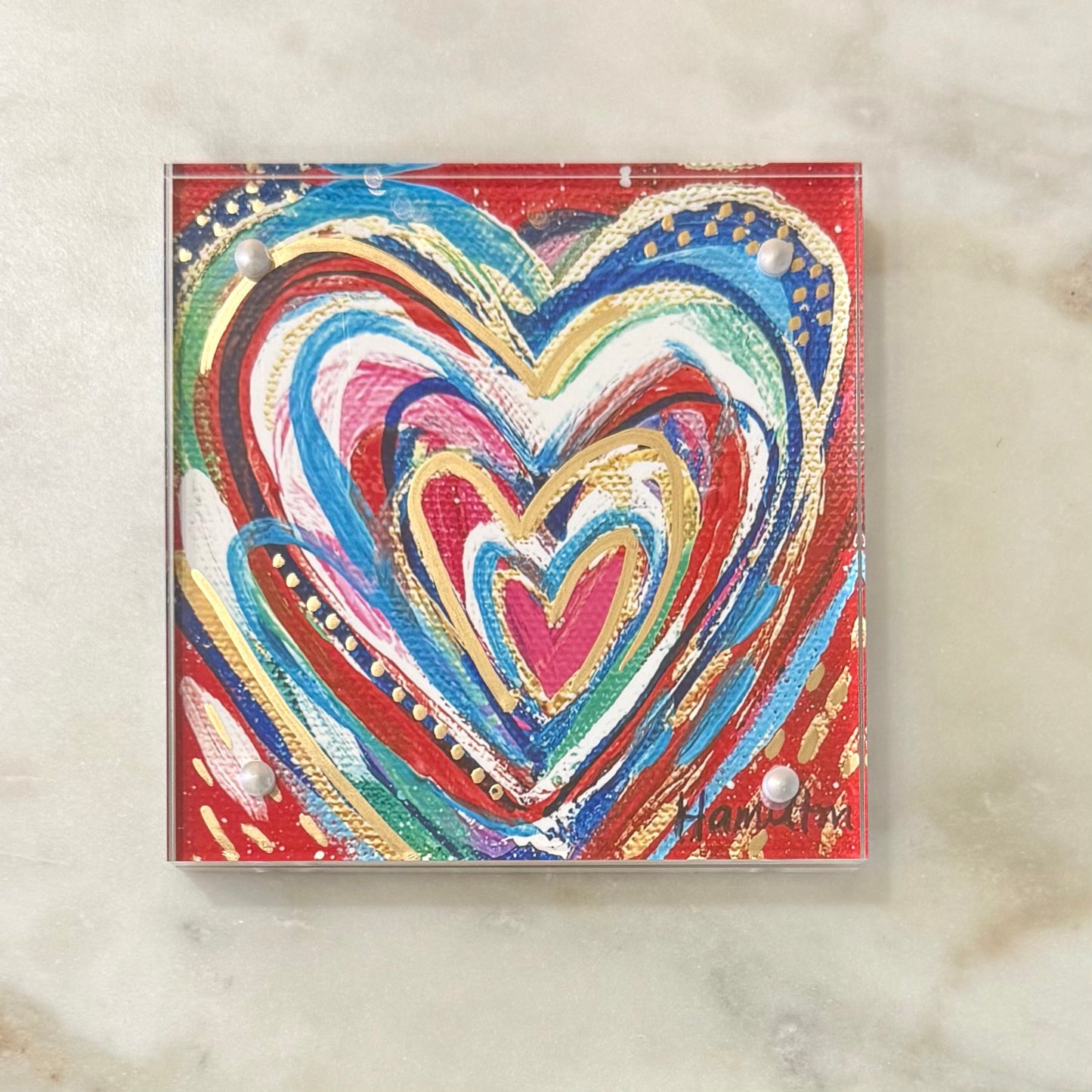 Colorful heart design on a red background with a white marble surface