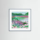 Framed art print of a colorful floral landscape on a white wall