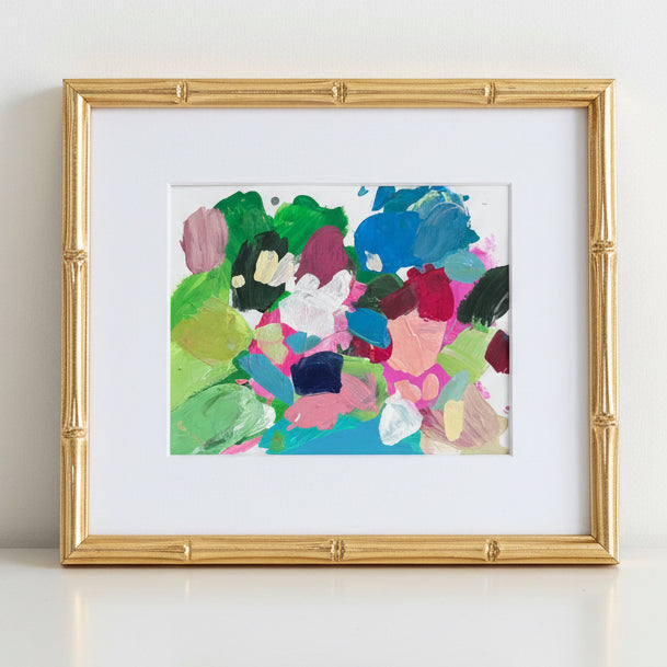 Framed abstract artwork of a colorful palette on a white wall