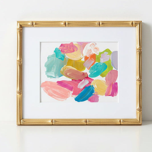 Framed abstract palette art with colorful brush strokes on a white wall