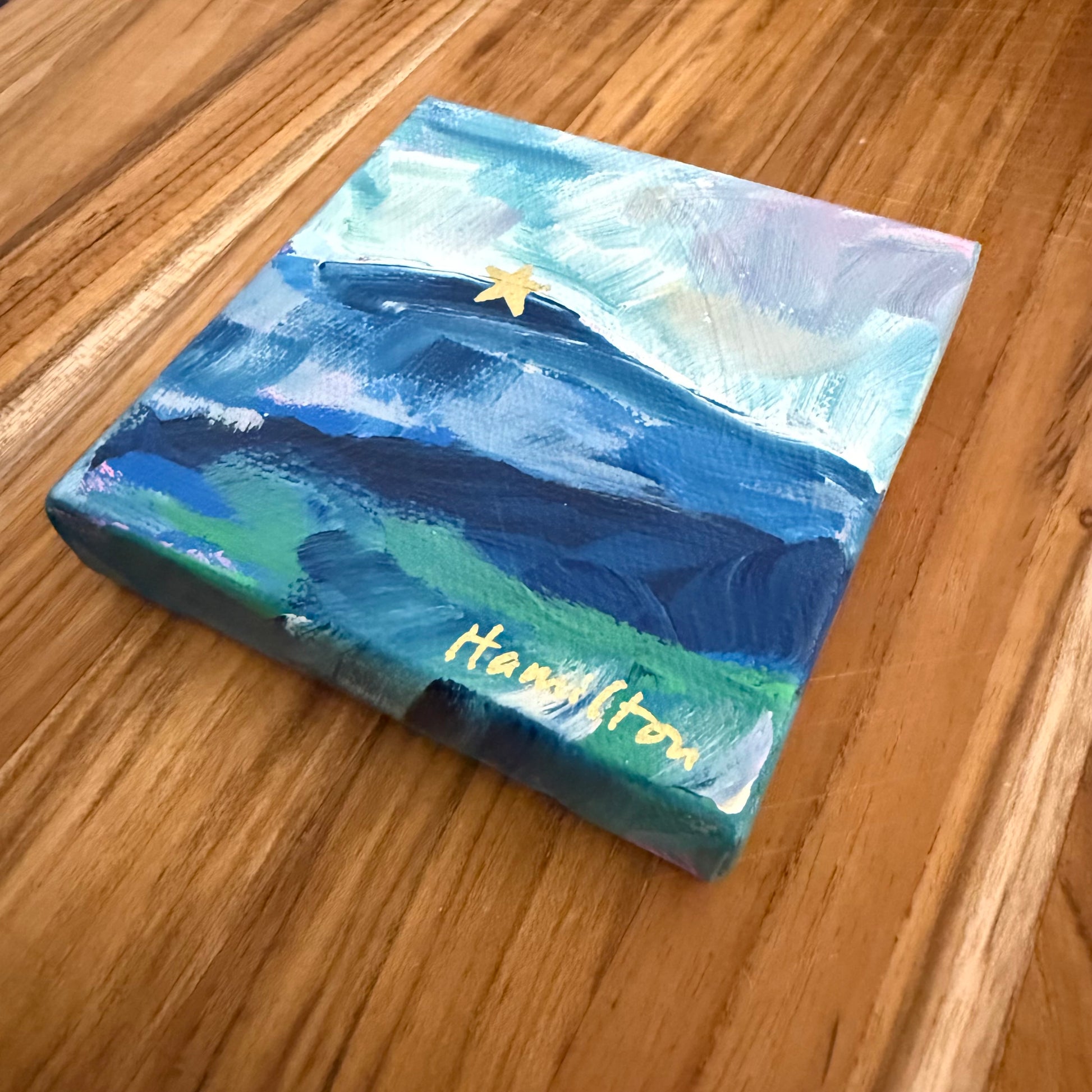 Small abstract landscape painting of the mill mountain star on wooden surface