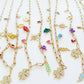 Gold necklaces with various colorful charms on a white background