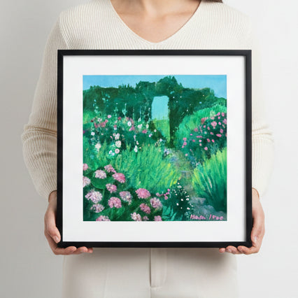 Framed artwork of a garden scene with pink flowers and greenery, surrounded by decorative ribbons and scissors on a white background.